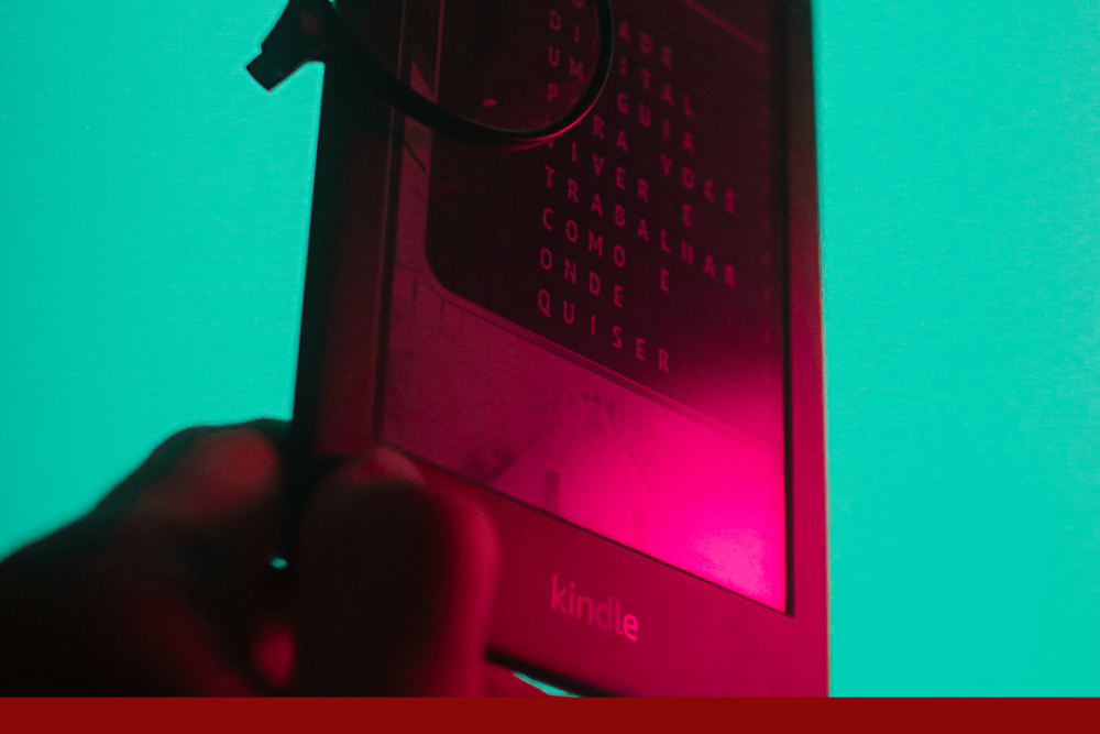 E-Reader mit aufgelegter Brille in rötlichem Licht vor türkisem Hintergrund, darunter der Schriftzug www.dunkelrot.de