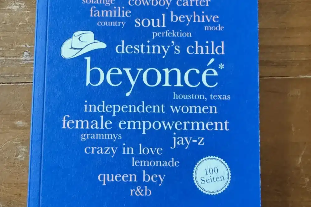 Cover des Buches beyoncé. 100 Seiten von André Boße, erschienen im Reclam Verlag, auf Holztisch fotografiert