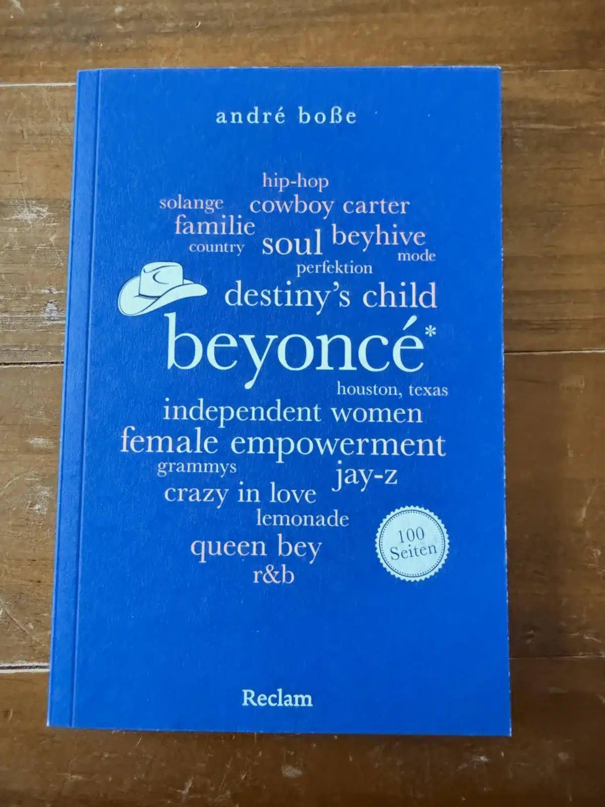 Beyoncé 100 Seiten Rezension: Cover des Buches von André Boße, erschienen im Reclam Verlag, auf Holztisch fotografiert