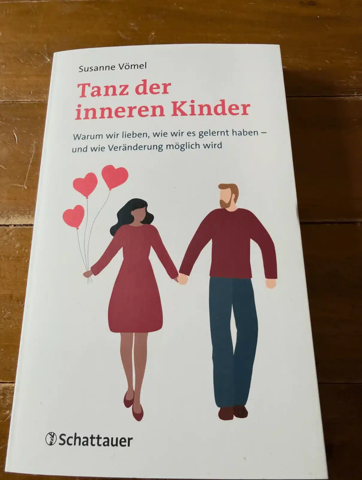 Tanz der inneren Kinder Rezension: Cover des Buches von Susanne Vömel, erschienen bei Schattauer/Klett-Cotta, auf Holztisch fotografiert