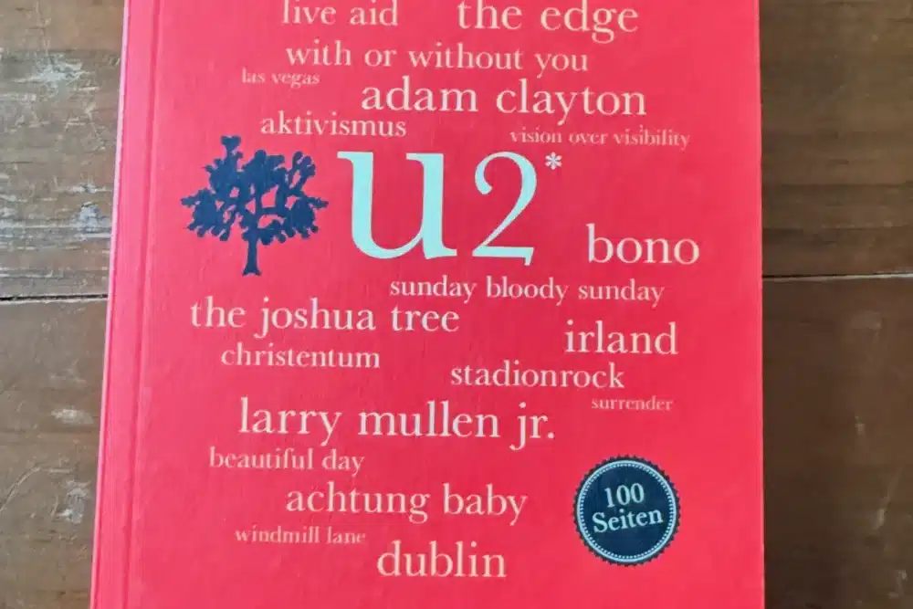 Cover des Buches U2. 100 Seiten von Birgit Fuß, erschienen im Reclam Verlag, auf Holztisch fotografiert