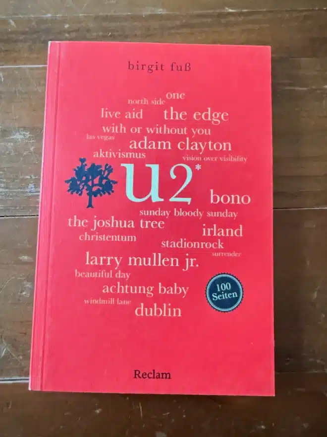Cover des Buches U2. 100 Seiten von Birgit Fuß, erschienen im Reclam Verlag, auf Holztisch fotografiert