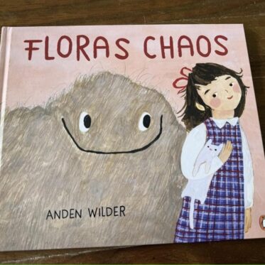 Floras Chaos Rezension: Cover des Bilderbuchs von Anden Wilder auf Holztisch