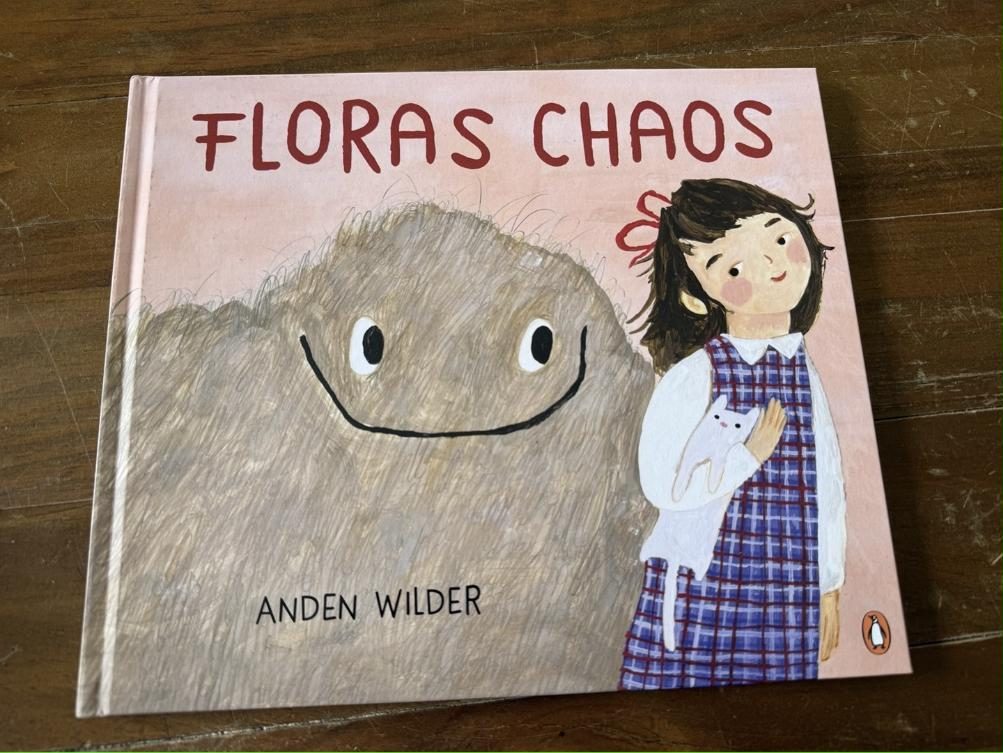 Floras Chaos Rezension: Cover des Bilderbuchs von Anden Wilder auf Holztisch
