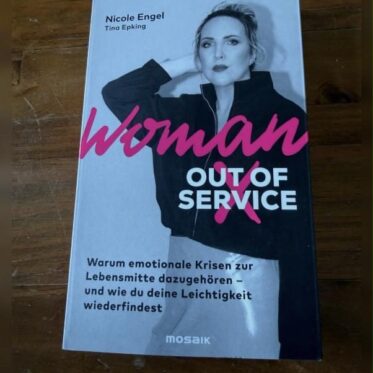 Woman Out of Service Rezension: Cover des Buches von Nicole Engel und Tina Epking auf Holztisch