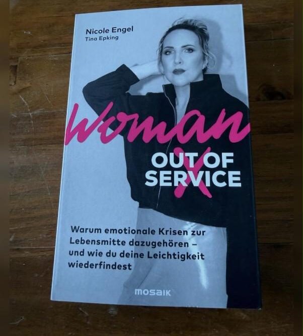 Woman Out of Service Rezension: Cover des Buches von Nicole Engel und Tina Epking auf Holztisch