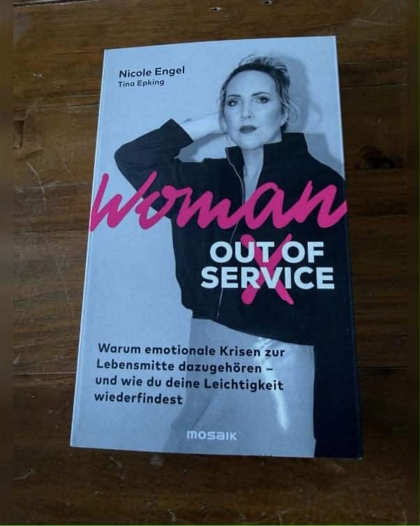 Woman Out of Service Rezension: Cover des Buches von Nicole Engel und Tina Epking auf Holztisch